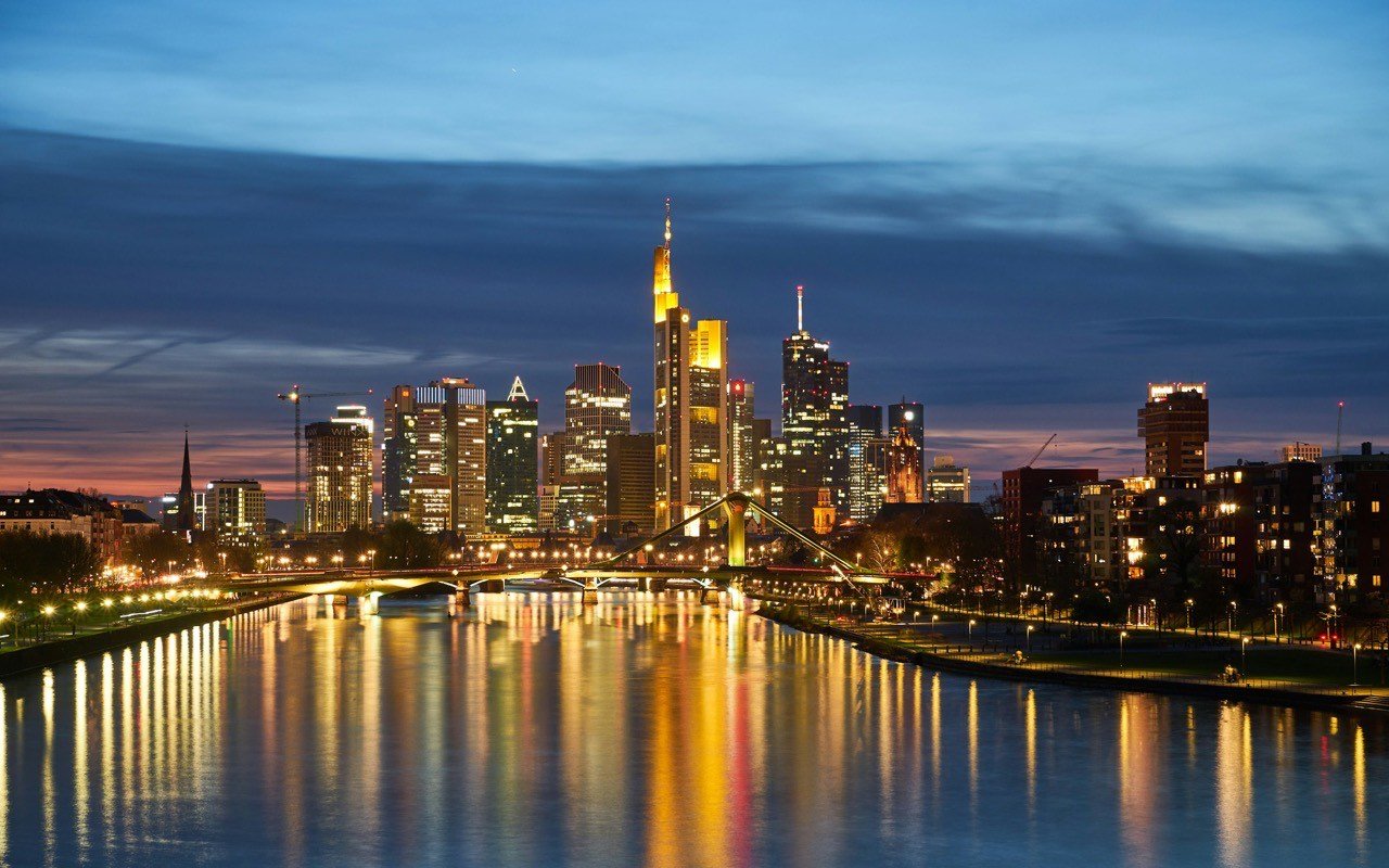 Frankfurter Skyline zur blauen Stunde, Lichter spiegeln sich im Main