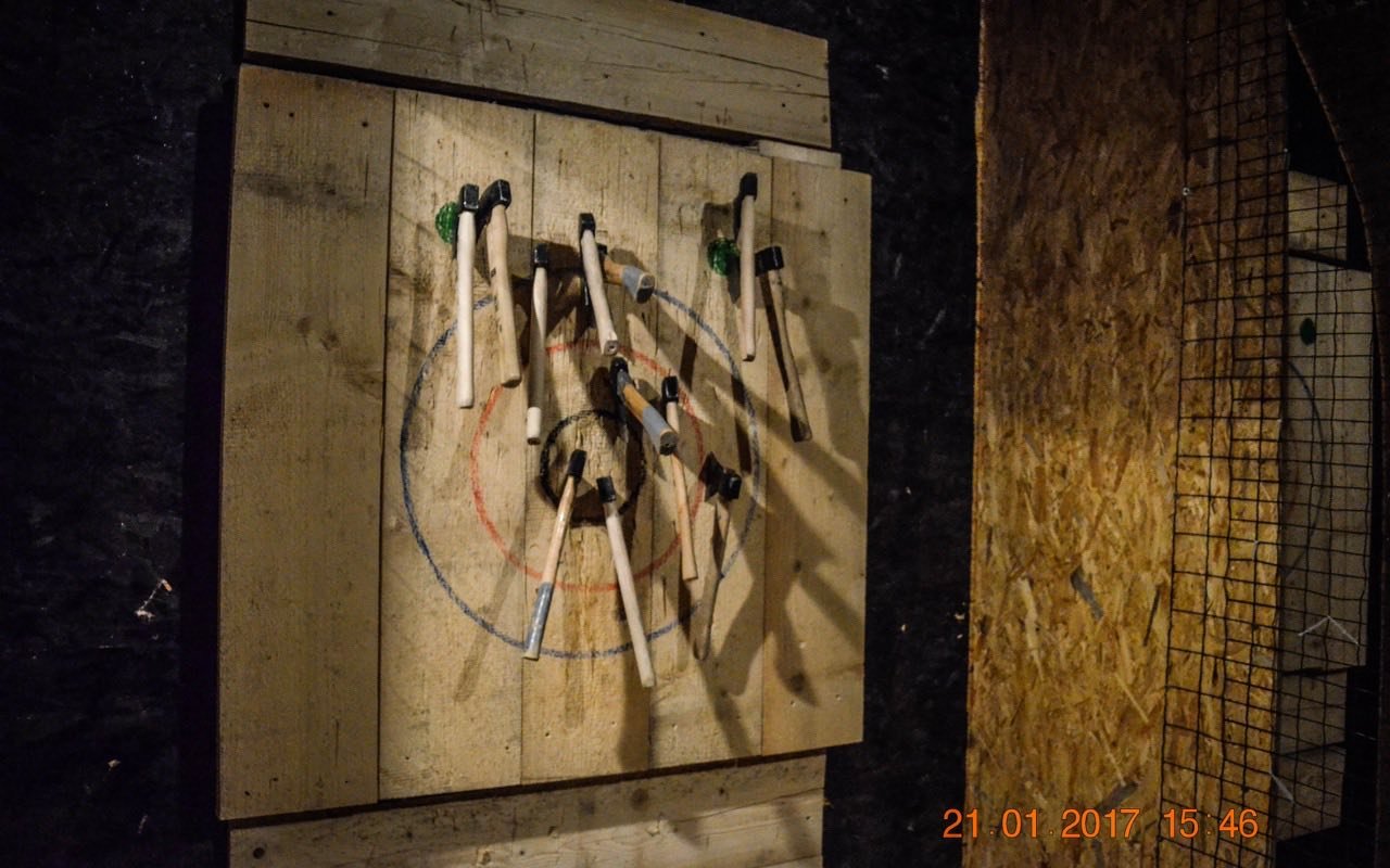 Symbolbild Axtwerfen: Holzbrett mit Äxten