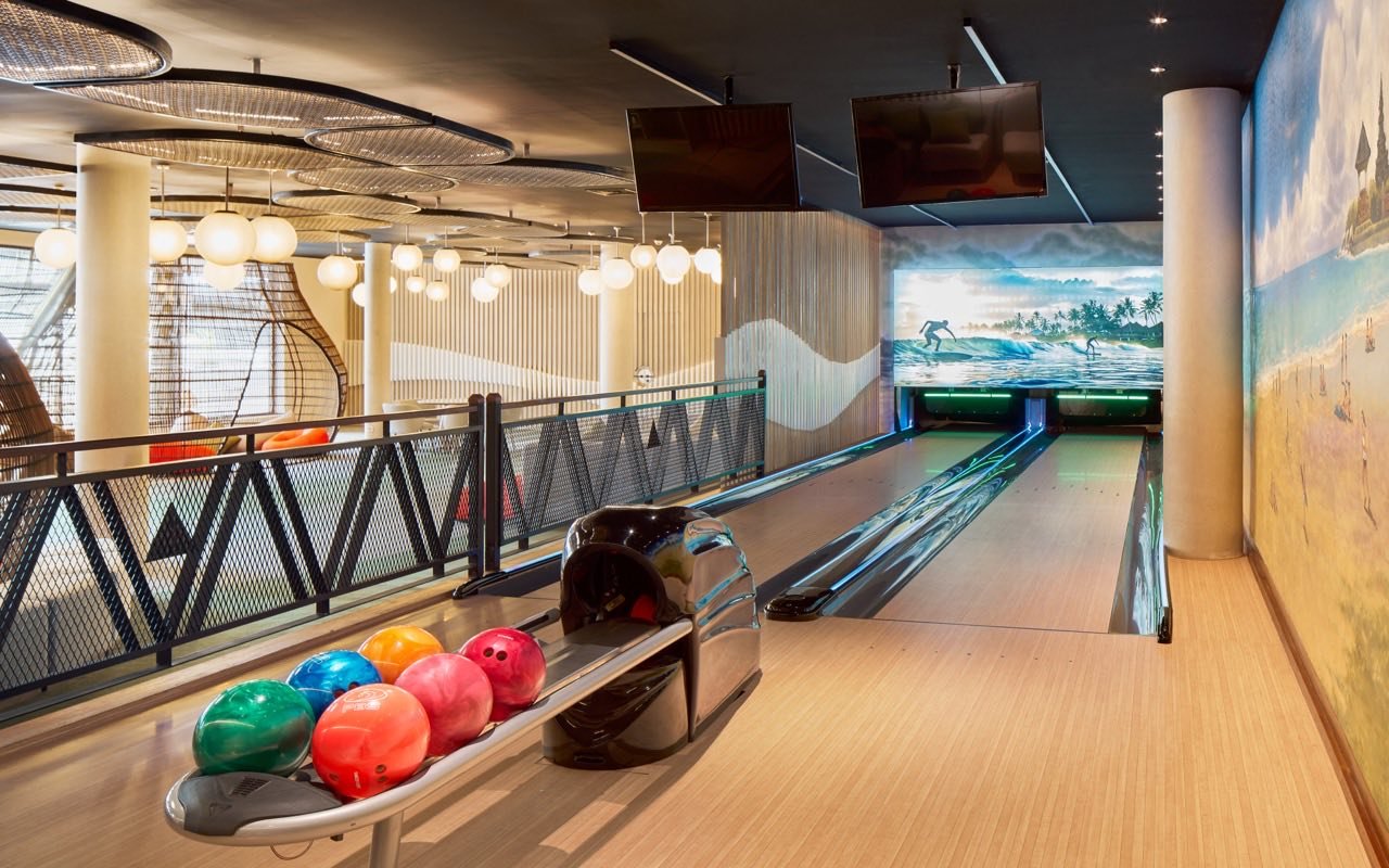 Symbolbild Bowling: Bunte Bowlingkugeln vor den Bahnen