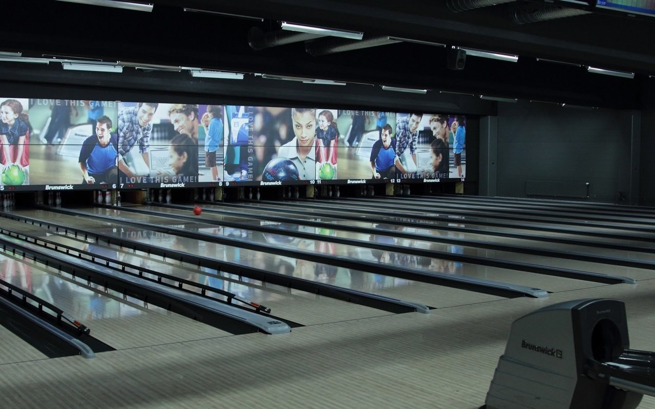 Symbolbild Bowling: Bowlingbahnen vor einer großen Videowand