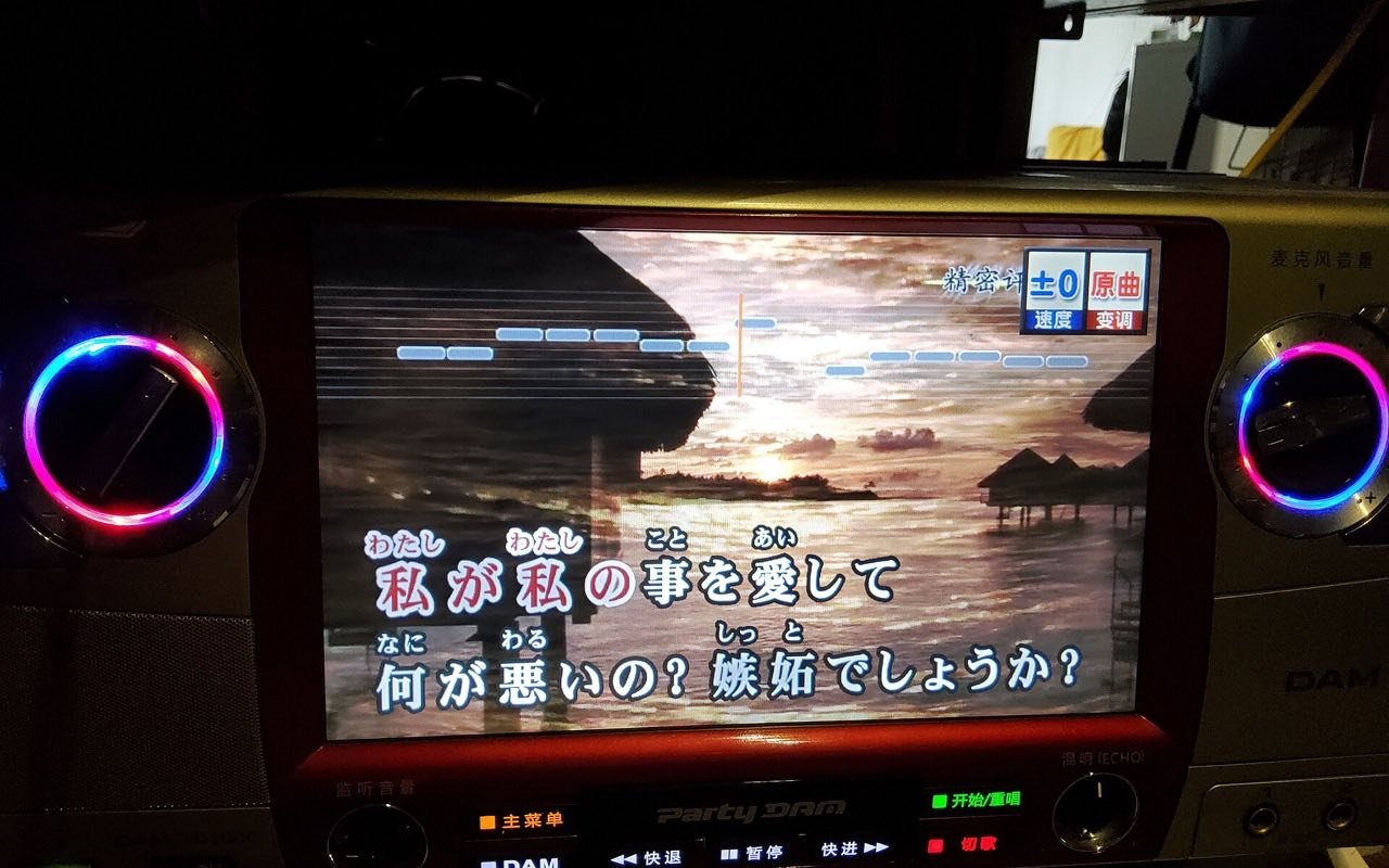 Symbolbild Karaoke: Karaokegerät mit Bildschirm, auf dem ein Liedtext über einem Sonnenuntergang steht