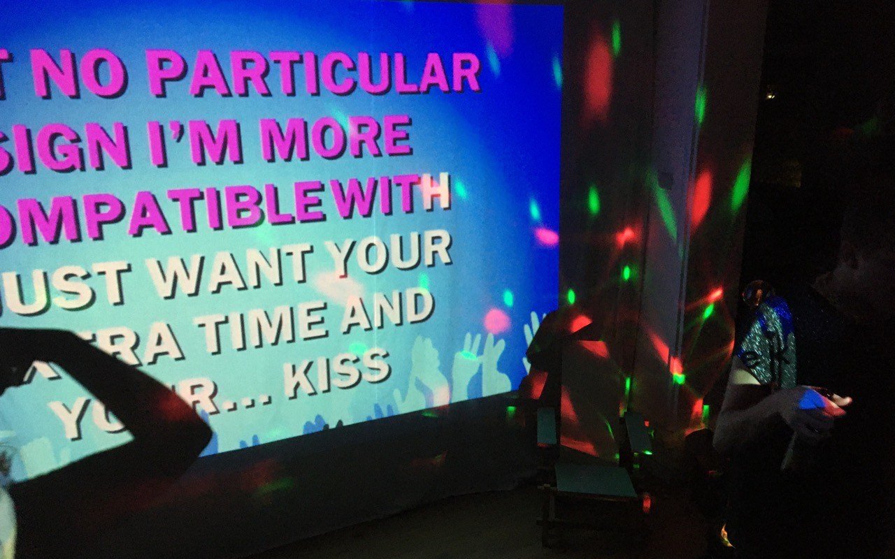 Symbolbild Karaoke: Karaoke Liedtext auf der Leinwand mit bunten Lichtern
