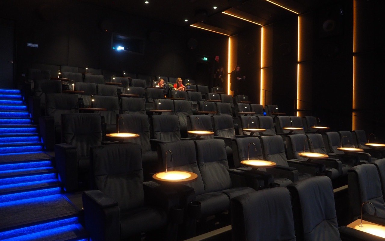 Symbolbild Kino zum Mieten: Moderner Kinosaal mit dunklen Sesseln