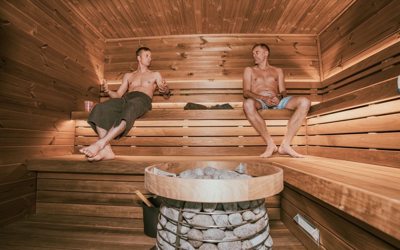 Symbolbild Museum: Zwei Männer entspannen in einer warmen Holzsauna